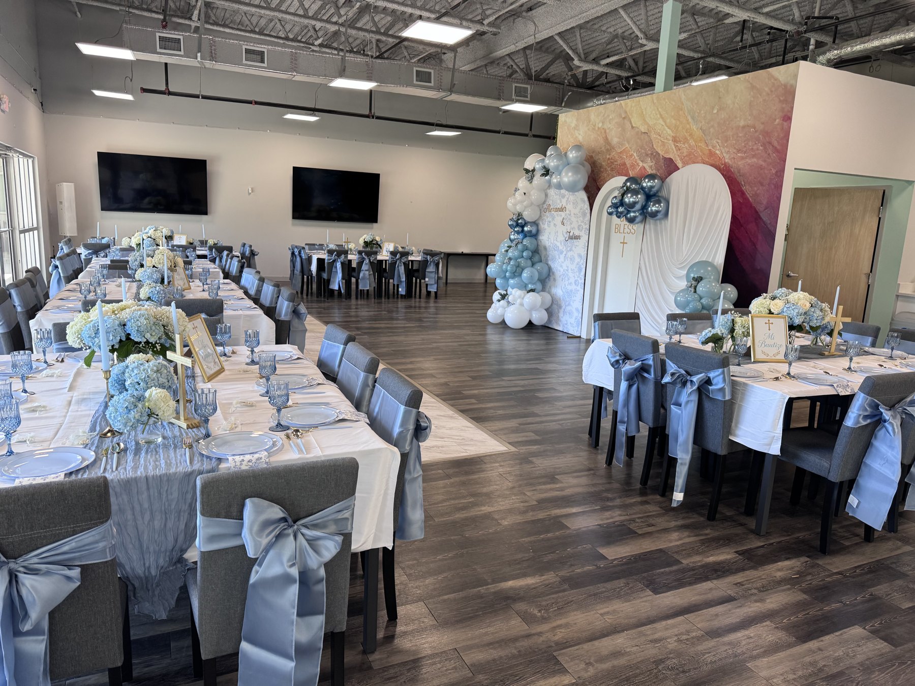 Blue-and-white celebration with floral table settings, chair bows and balloon backdrops.